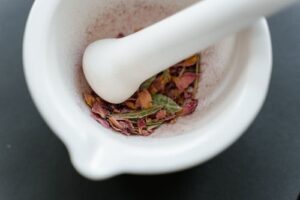 乳鉢と乳棒で乾燥させたバラの花びらをすり潰す