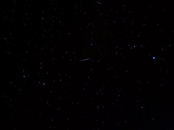 流れ星が横切る満天の星空