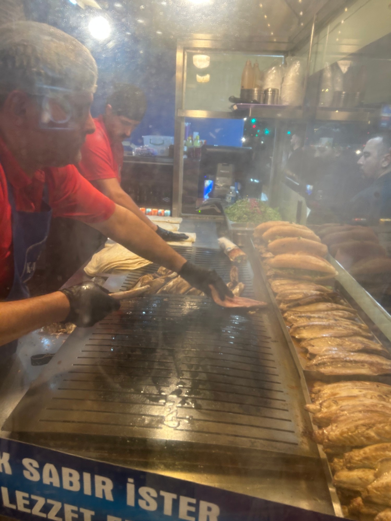 焼き台でサバを焼く店員